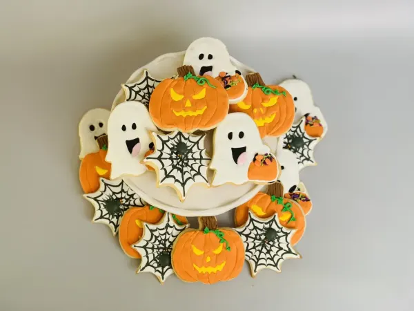 Halloween cookies with jack-o-lanterns, smiling ghosts and black spiderwebs with spiders