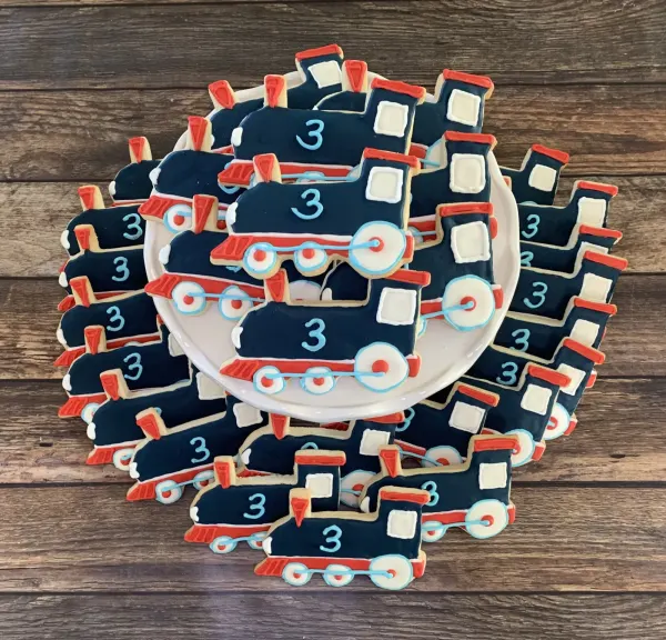 Navy and red train engine cookies piped with a light blue number 3