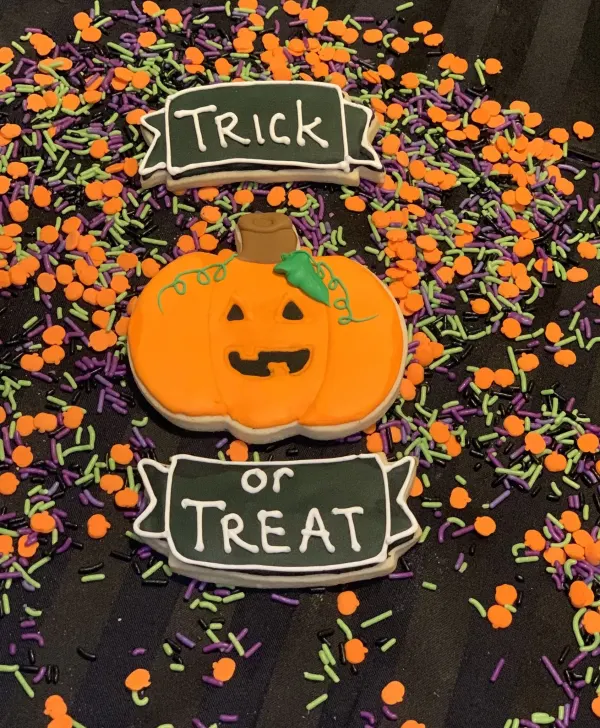 Halloween cookies spelling Trick or Treat on banners with a jack-o-lantern pumpkin