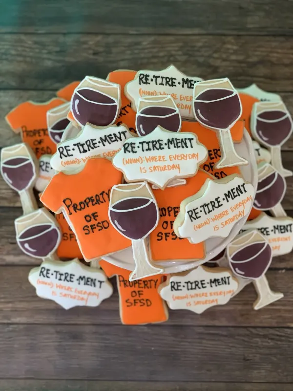 Retirement cookies with red wine glasses, orange Property of SFSD shirts and definition plaques