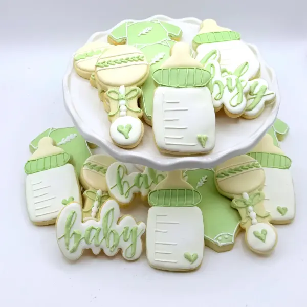 Sage green baby shower cookies with bottles, rattles, onesies and baby lettered in script