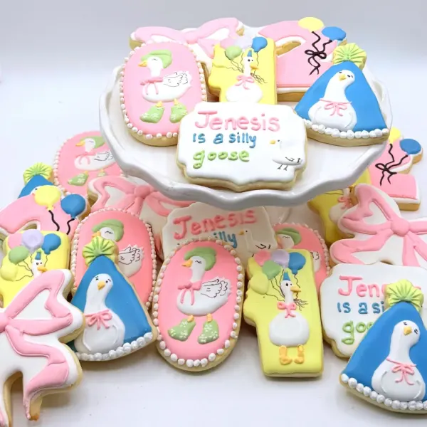 Pink first birthday cookies with geese, bows and balloons lettered Jenesis is a silly goose
