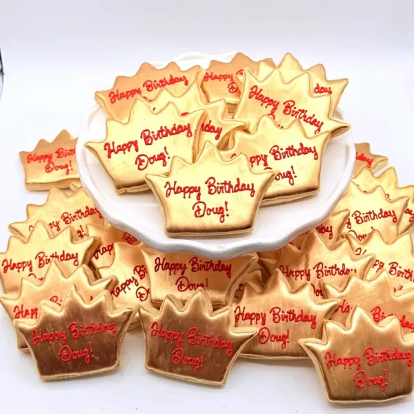 Gold crown cookies each lettered Happy Birthday Doug in red script