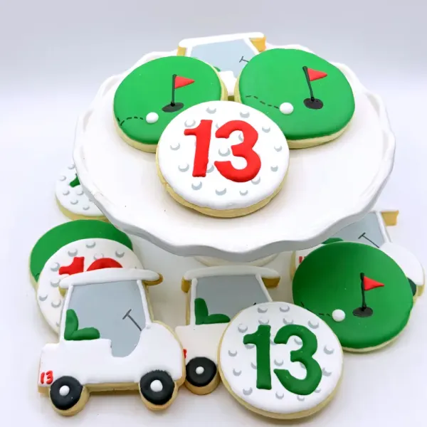 Golf cookies with putting greens, red flags, a golf cart and golf balls numbered thirteen