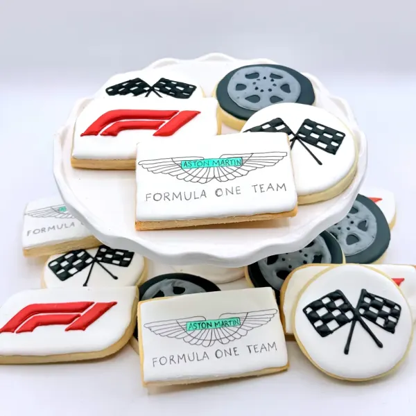 Formula One cookies with checkered flags, tires, a red logo and racing team plaques