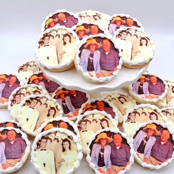 Round cookies with edible photo prints of a couple, each finished with a piped white border