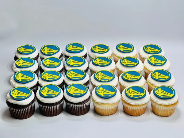 Two dozen chocolate and vanilla cupcakes topped with blue and yellow bridge logo fondant discs