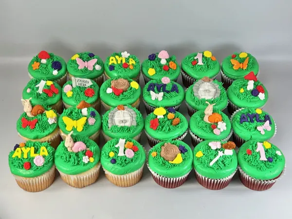 Green grass-piped fairy garden cupcakes with AYLA, number 1, butterflies, mushrooms and snails