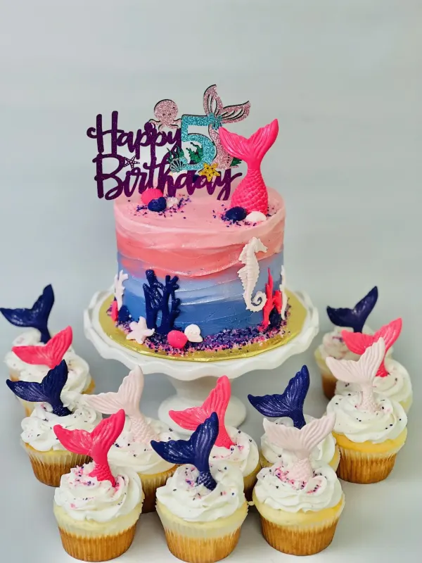 Pink and blue ombre mermaid cake with a Happy Birthday 5 topper and mermaid tail cupcakes