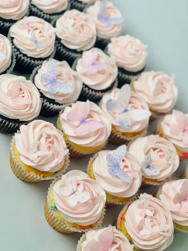Pale pink swirl cupcakes topped with pink and purple wafer paper butterflies