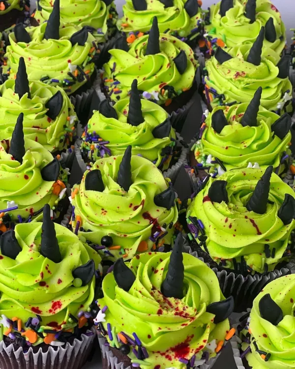 Chocolate cupcakes with lime green frosting, black fondant horns and ears and Halloween sprinkles