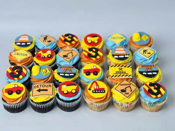 Construction cupcakes with fondant road signs, dump trucks and number 3, one topper reading Rhodes