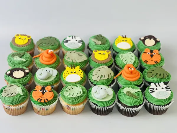Jungle cupcakes with green frosting and fondant lion, zebra, tiger, monkey, snake and leaf toppers