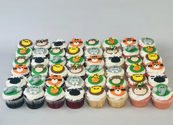 Safari cupcakes with white frosting and fondant lion, hippo, tiger, elephant and giraffe faces