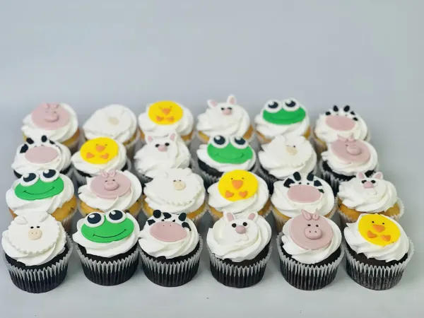 Farm animal cupcakes with white frosting and fondant pig, cow, chick, sheep, frog and bunny faces