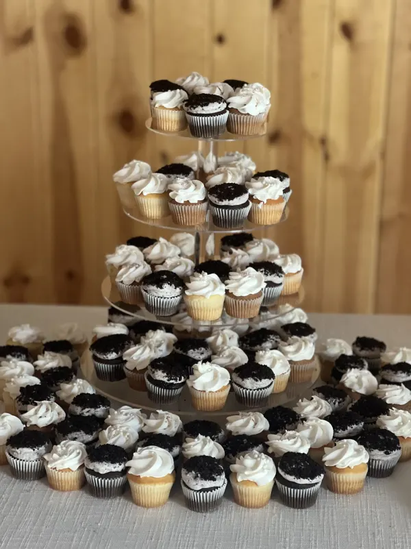 Tiered tower of cookies-and-cream cupcakes with white frosting swirls and dark cookie crumb