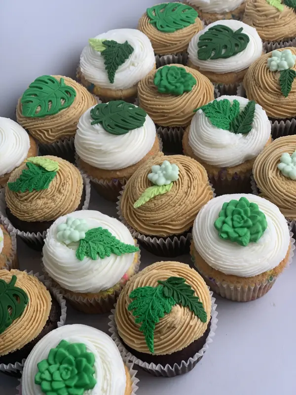 Cupcakes in white and caramel buttercream with fondant monstera leaves, ferns and succulents