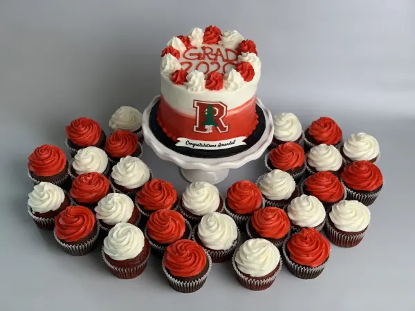 Cake iced GRAD 2020 with a redwood crest and Congratulations Amanda banner, with red and white cupcakes