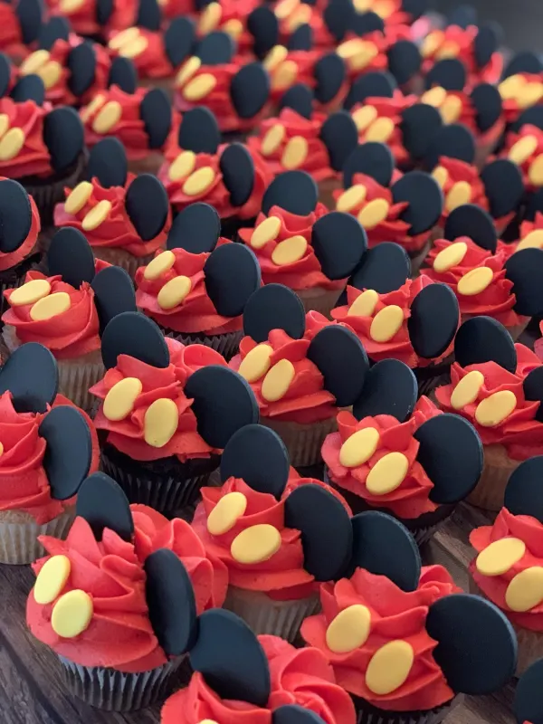 Cupcakes with red buttercream, black fondant mouse ears and pairs of yellow fondant buttons