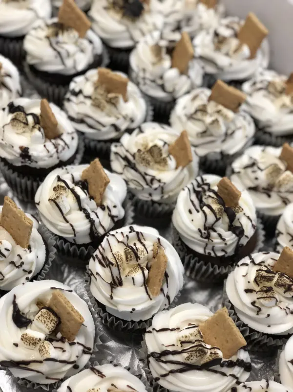 S'mores cupcakes with white buttercream, toasted marshmallows, graham cracker and chocolate drizzle