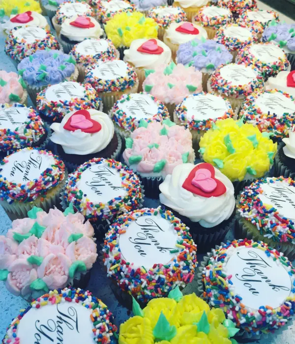Cupcakes with Thank You discs, rainbow sprinkle rims, piped flowers and red fondant hearts