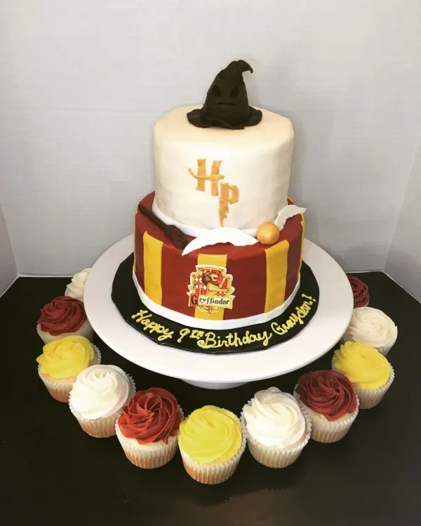 Two-tier Harry Potter cake with a sorting hat topper, Gryffindor crest and Happy 9th Birthday