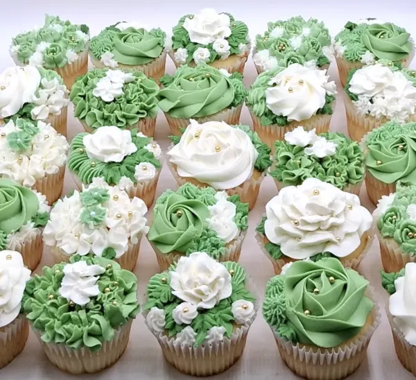Melissa wedding cupcakes piped in sage green and white buttercream roses and ruffles, finished with gold sugar pearls, 2026